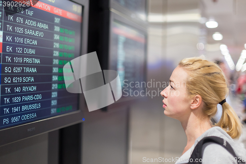 Image of Passenger looking at flight information board.