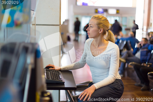 Image of Woman public internet access point on airport.