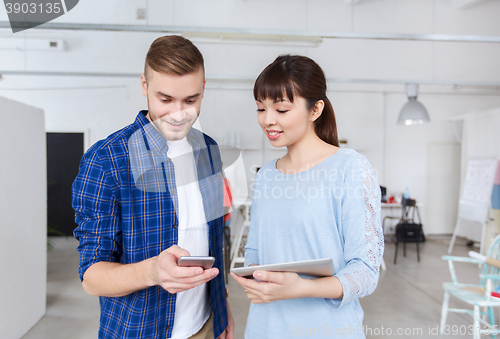 Image of couple with smartphone and tablet pc at office