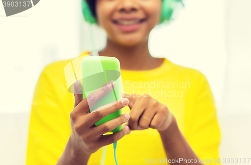 Image of happy african woman with smartphone and headphones