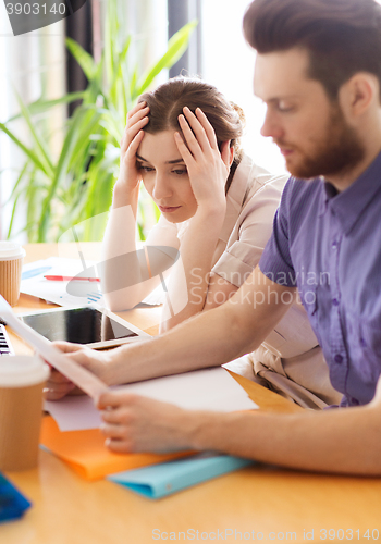 Image of creative team with reading paper in office