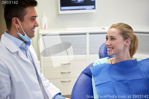 Image of happy male dentist with woman patient at clinic