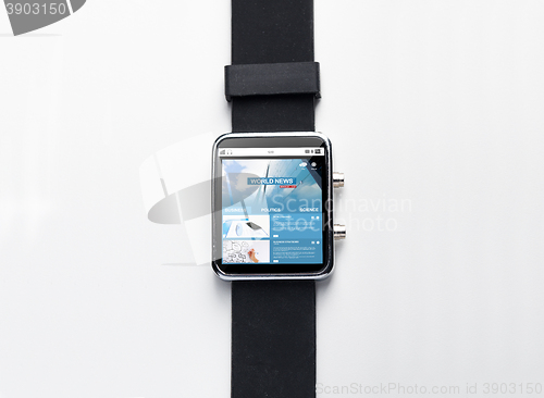 Image of close up of black smart watch with world news page