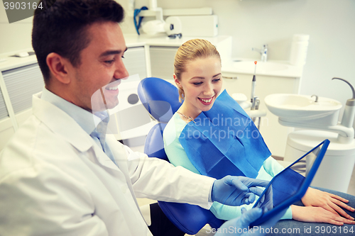 Image of male dentist with tablet pc and woman patient