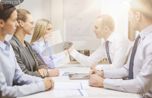 Image of businesswoman and businessman arm wrestling