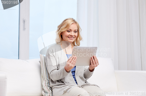 Image of happy middle aged woman with tablet pc at home