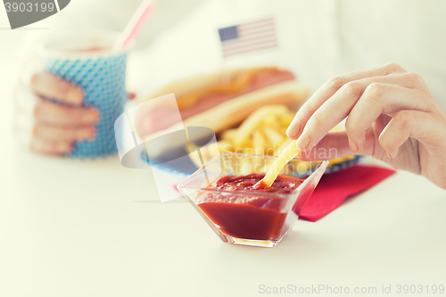 Image of close up of woman hands eating on american food