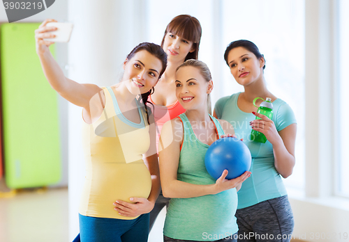 Image of pregnant women taking selfie by smartphone in gym