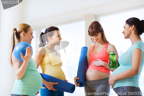 Image of group of happy pregnant women talking in gym