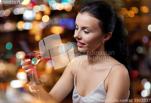 Image of glamorous woman with cocktail at night club or bar