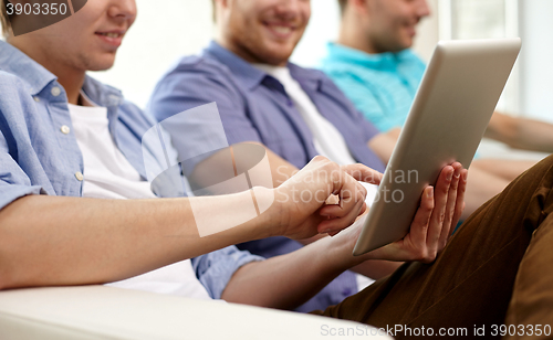 Image of close up of happy friends with tablet pc at home