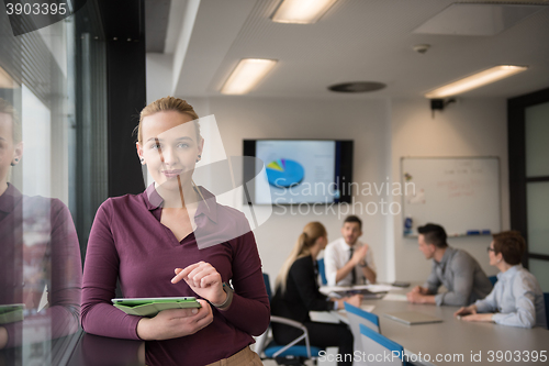 Image of blonde businesswoman working on tablet at office