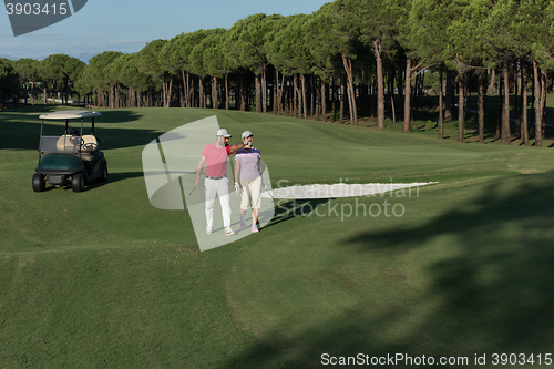 Image of couple walking on golf course