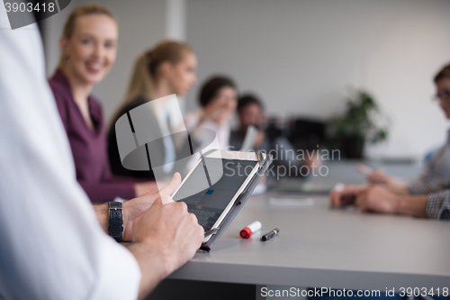 Image of close up of  businessman hands  using tablet on meeting