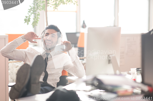 Image of relaxed young business man at office