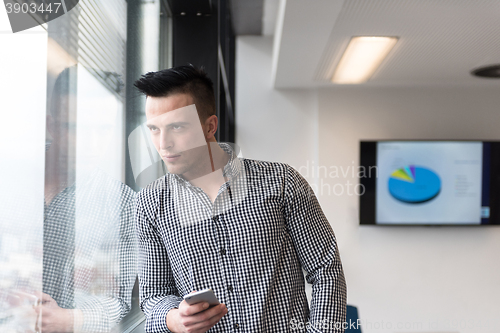 Image of young business man using smart phone at office