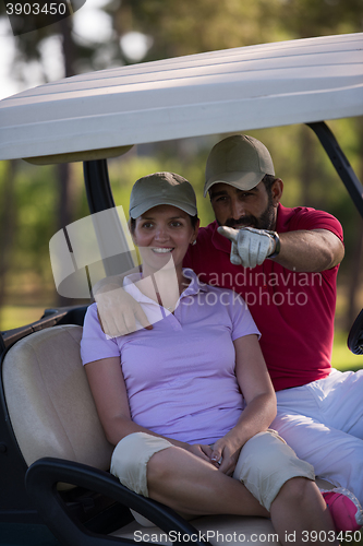 Image of couple in buggy on golf course