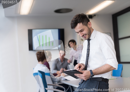 Image of young business man with tablet at office meeting room