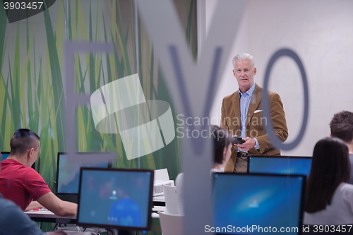Image of teacher and students in computer lab classroom