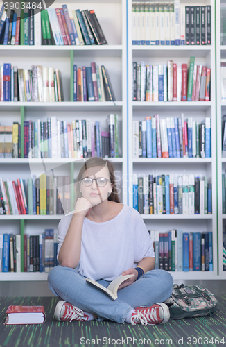 Image of famale student reading book in library