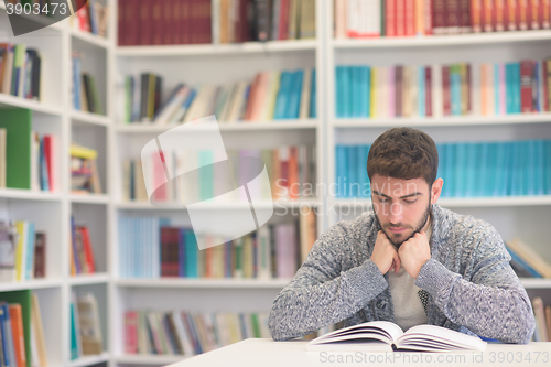 Image of portrait of student while reading book  in school library