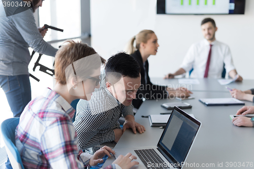 Image of young business couple working on laptop, businesspeople group on