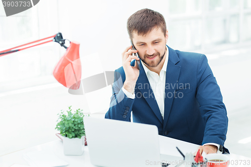 Image of Portrait of businessman talking on phone in office