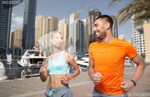 Image of couple running over dubai city street background