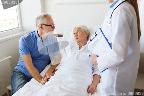 Image of senior woman and doctor with clipboard at hospital