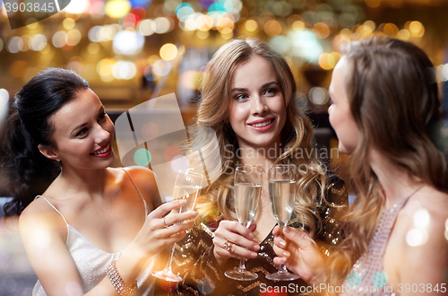 Image of happy women with champagne glasses at night club