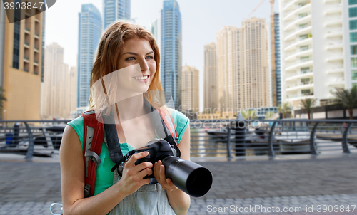 Image of woman with backpack and camera over dubai city