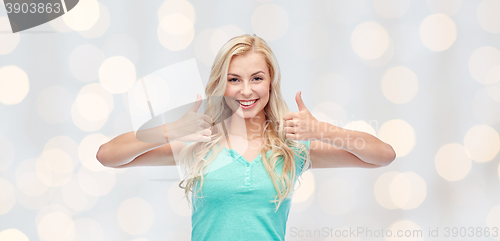 Image of happy woman or teenage girl showing thumbs up