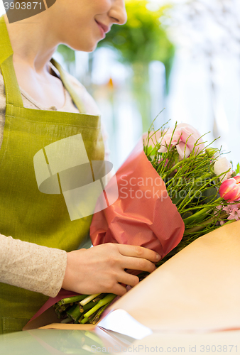 Image of close up of woman packing bunch at flower shop