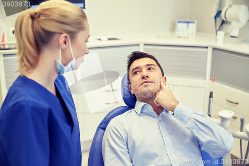 Image of male dentist with woman patient at clinic