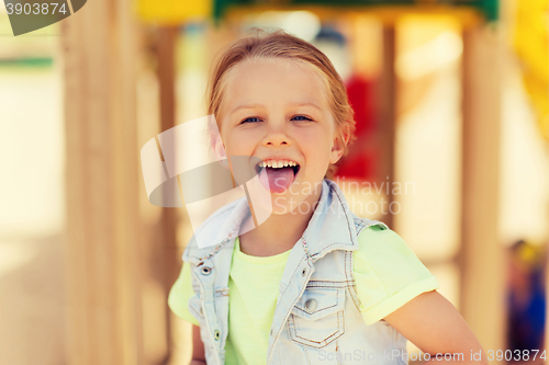 Image of happy little girl showing tongue on playground