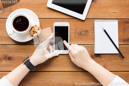 Image of close up of woman with smartphone on wooden table