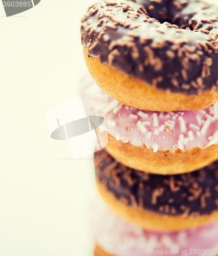 Image of close up of glazed donuts pile over white