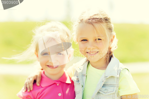 Image of happy little girls hugging outdoors at summer