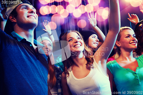 Image of smiling friends at concert in club