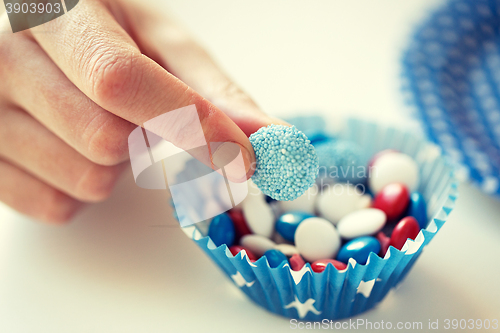 Image of close up of hand with candies on independence day