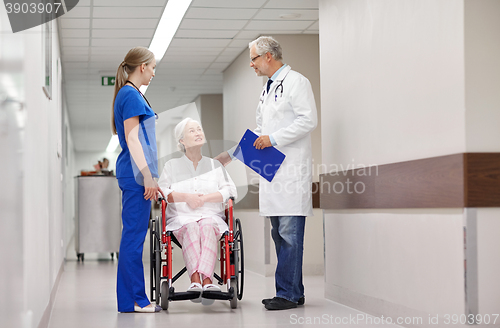 Image of medics and senior woman in wheelchair at hospital