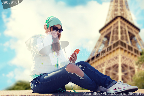 Image of happy young woman with smartphone and headphones
