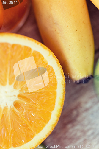 Image of close up of fresh juicy orange and banana on table