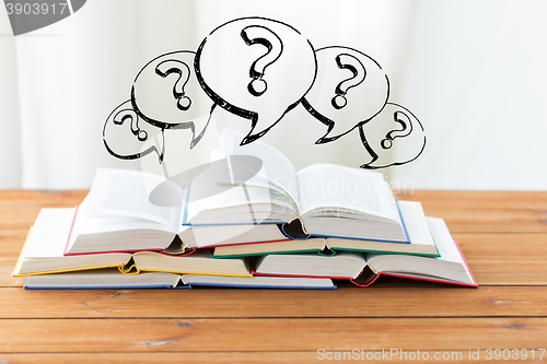 Image of close up of books on table and question marks