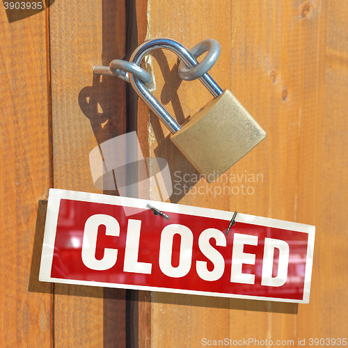 Image of Padlock on a wood door with closed sign