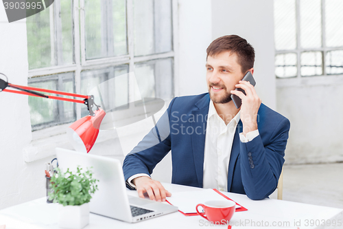 Image of Portrait of businessman talking on phone in office