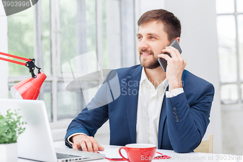 Image of Portrait of businessman talking on phone in office