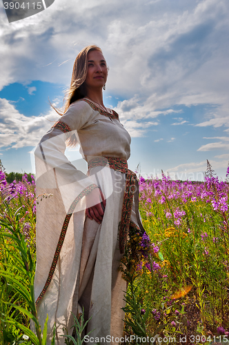 Image of Beautiful girl relaxing among flowers