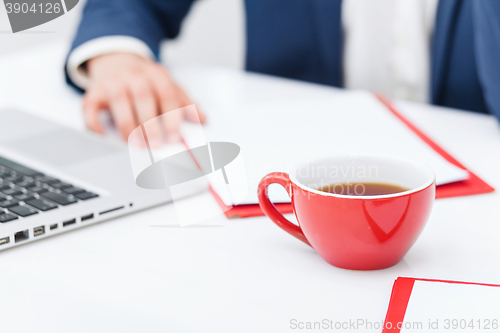 Image of Businessman having coffee break, he is holding a cup 