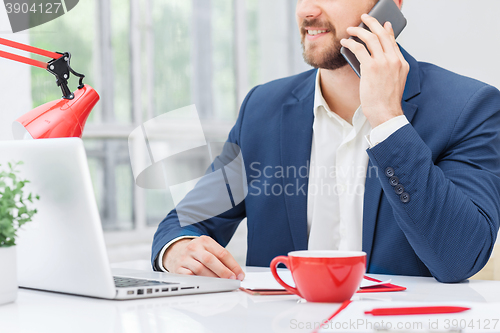 Image of Portrait of businessman talking on phone in office